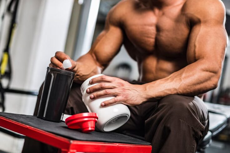  A man is presenting a bottle of creatine protein powder, highlighting its use for fitness and muscle recovery.