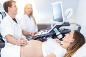 Brunette woman having early pregnancy scan at clinic