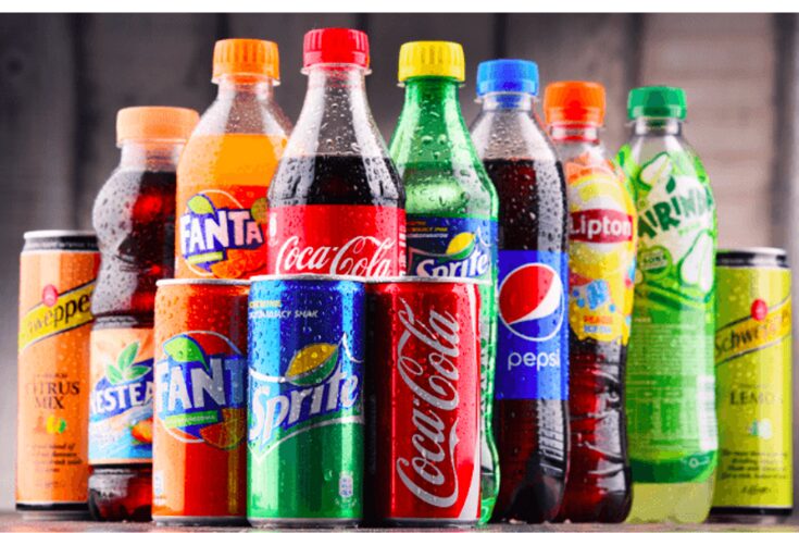  A variety of sugary sodas and drinks displayed together, showcasing colorful cans and bottles.