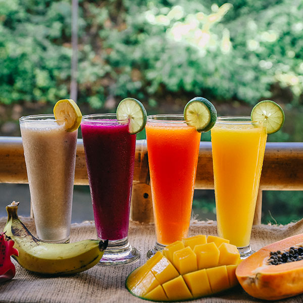 A table displays five different colored smoothies, each in a unique hue, highlighting a variety of refreshing options.
