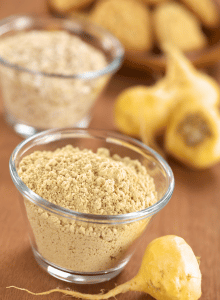 maca powder in glass bowl with macca roots