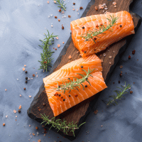 Raw Salmon on Wooden Board with Herbs