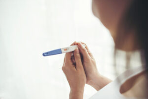 Woman holding positive pregnancy test